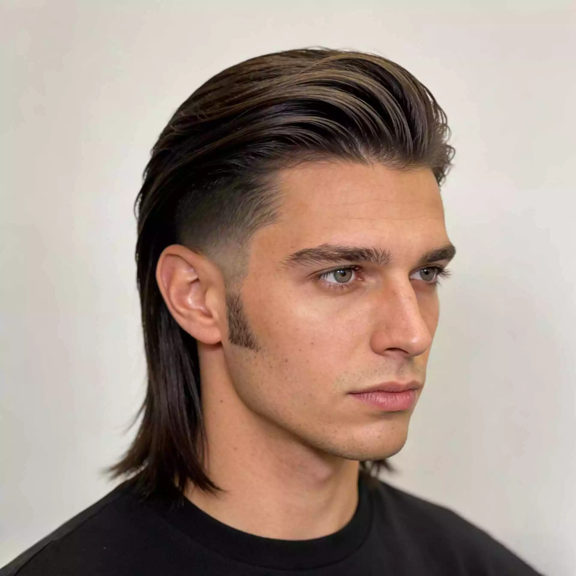 soft brush back low taper with long hair on top — straight hair men with natural movement and clean tapered edges