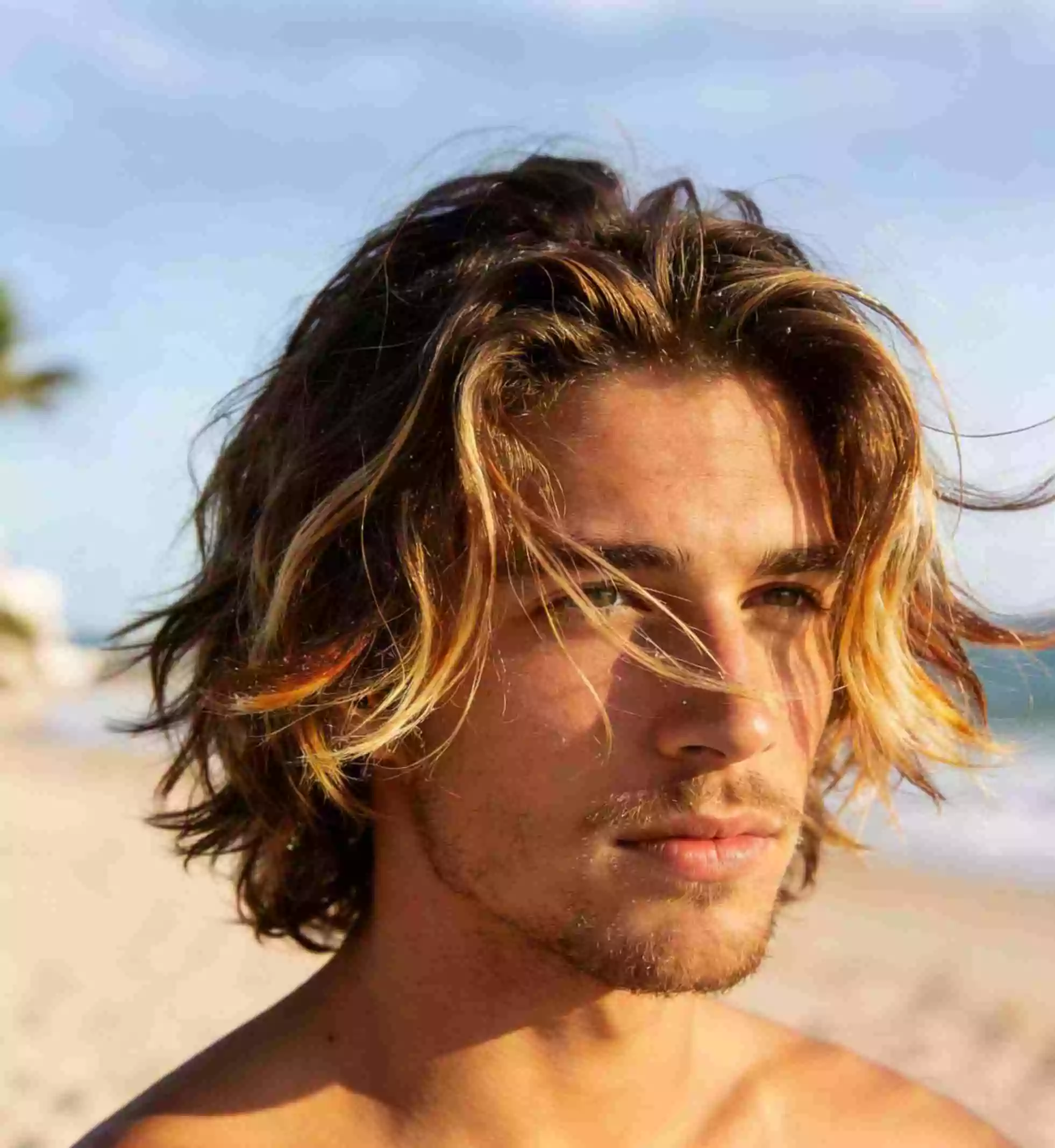 medium surfer hair for men with airy layered shag and beachy separation